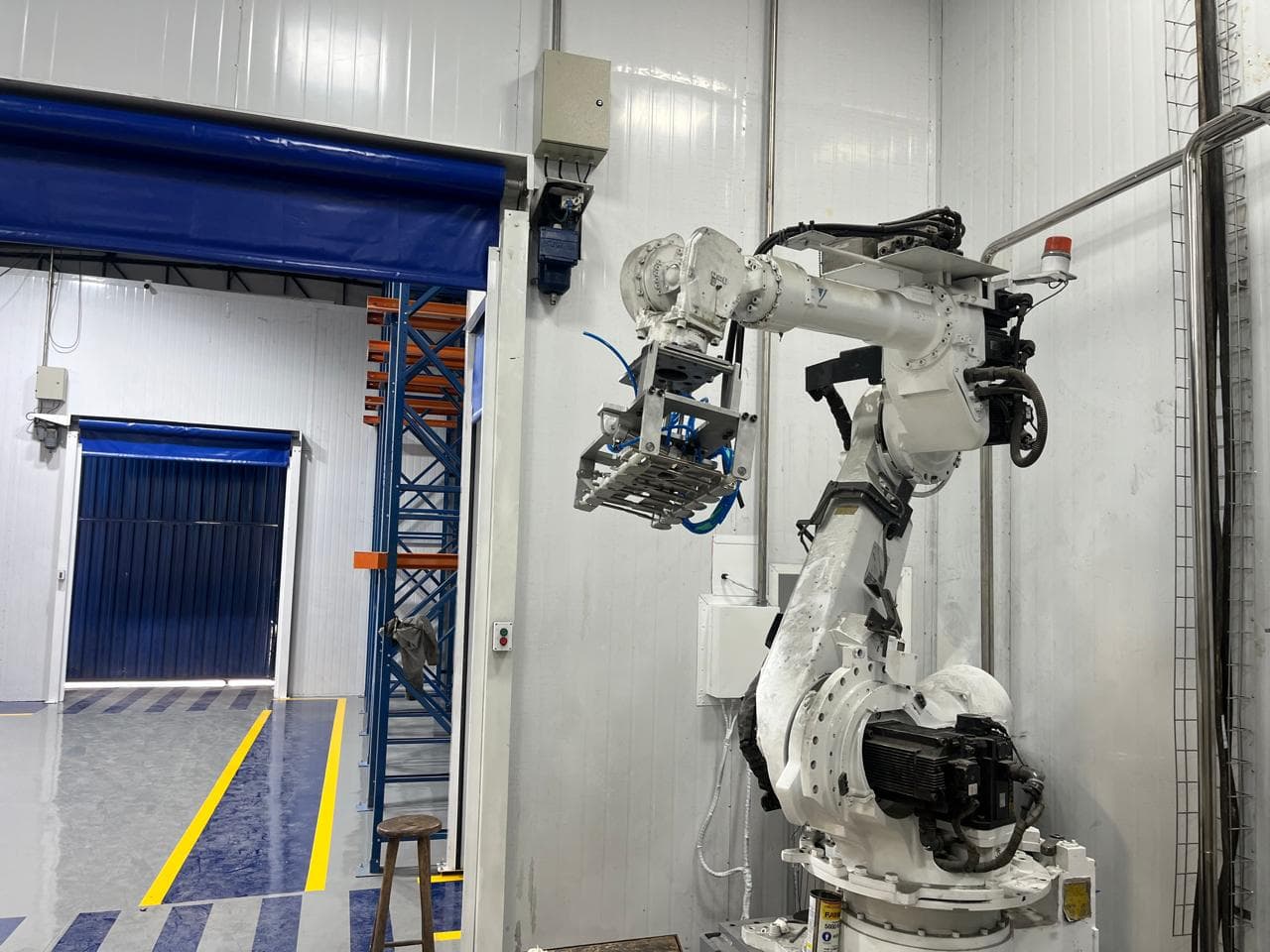 Robô industrial instalado em área de produção automatizada.